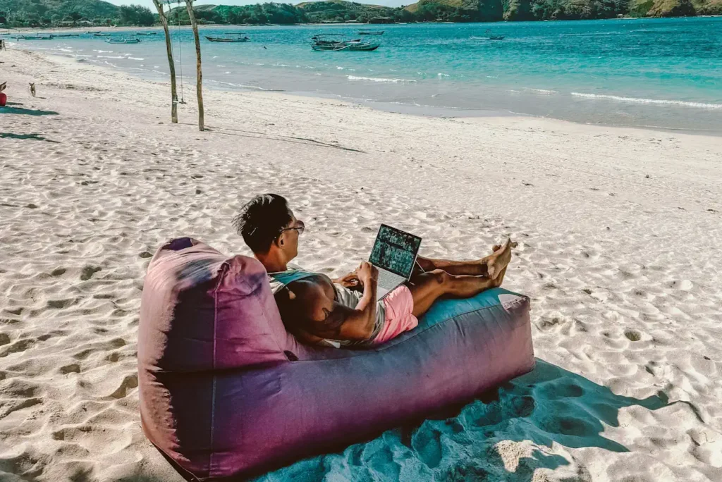 Montenegro Digital Nomad Visa Nomad sitting on beach with laptop